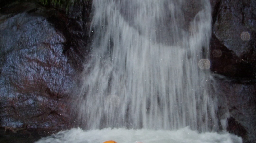 a man standing next to a waterfall
