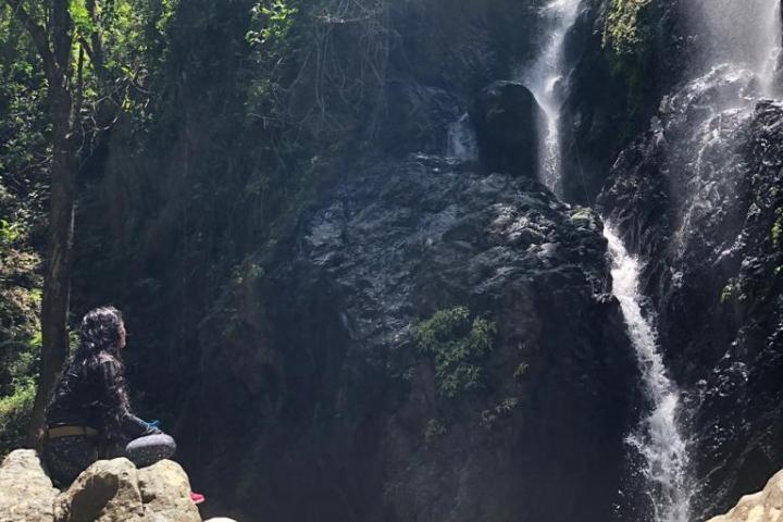 a group of people standing next to a waterfall